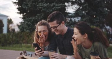 Genç arkadaşlar dışarıda bir şeye gülüyorlar.