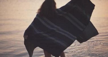 Sahilde Gün Batımı'nda yürüyen kadın