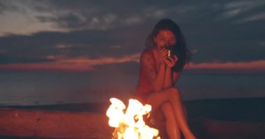 Kız şenlik ateşi yakınında sıcak içecek içme