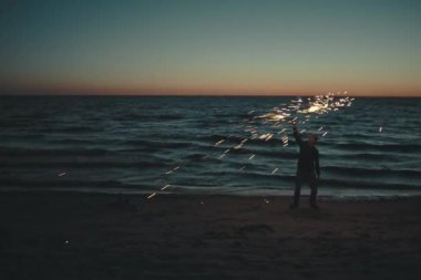 Deniz sahilinde ateşle hokkabazlık eden adam