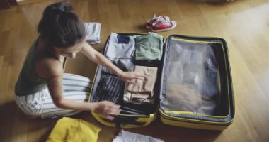 Kadın bir Bagaj ahşap zemin üzerinde ambalaj