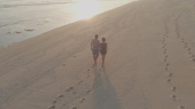 Güzel çift günbatımı plaj boyunca yürüyüş