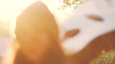 Siluet Güzel kız gün batımında çiçek sepeti ile çiçek çim fieid akustik guitalele oynayarak rahatlayın. vintage renk efekti