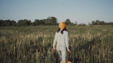 Güzel ve genç birbayan günbatımında gitar çalmak