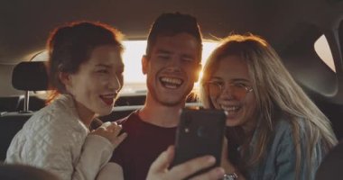 Tatil için ayrılmadan önce arabaya bir selfie alarak arkadaş grubu. Dört kişi, iki beyaz ve iki İspanyol bir karma yarış grup.