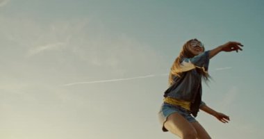 Kız gün batımında çölde kumların üzerinde atlıyor.