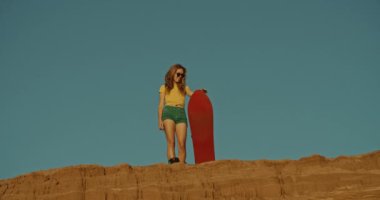 çölde bir uçurumda kadın sandboarder