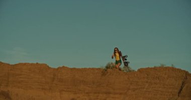 kız sandboarder bir uçuruma koşmak, gün batımı ışık