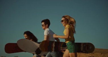 serin sandboarders çölde çalıştırmak, gün batımı ışık