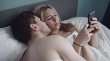 Heteroseksüel çift yatakta sorun yaşıyor. Cep telefonu bağımlılığı. Göreceli zorluklar. Efsanevi bir kadın ve erkek arkadaşına tazminat ödemiyor. Evlilik, ayrılık, aile, aşk, seks konsepti.