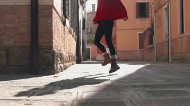 Venedik 'te parlak gün ışığında ilham arıyorum. Enfes, genç Asyalı, şık, kırmızı bir süveter giyen, antik dar sokaklar boyunca uzun bir geçmişi olan, yürüyen ve dönen bir kadının arka görüntüsü..