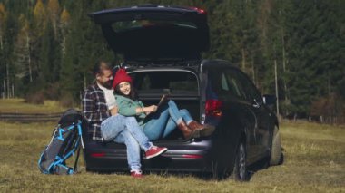 Toplumsal uzaklık. Uzun karantina sonrası yolculuklarında olan sevimli hippi genç bir çift. Güzel aşıklar harita üzerinde çalışıyorlar ve tatilleri boyunca arabada oturuyorlar..