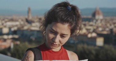 Santa Maria del Fiore 'un arka planında duran şehir haritasına bakan heyecanlı kadın turistin portresi. Yaz tatilinde romantik Floransa 'yı keşfeden esmer kadın profili.