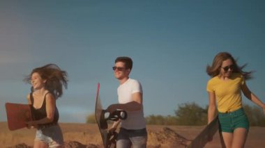 Snowboard ya da kum kaykayıyla kumda koşan çok ırklı arkadaşlar gülümsüyor ve zevk alıyorlar. Dubai tatil beldesinde bir grup genç insan. Arkadaşlık kavramı, ekstrem spor.