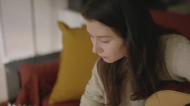 Müzisyen olmak isteyen biri dizüstü bilgisayarla müzik aleti çalmayı öğreniyor. Evde kal, tek başına takıl güzel kız online ders izliyor ve müzik çalışıyor. Genç Asyalı kadın evde gitar çalıyor..