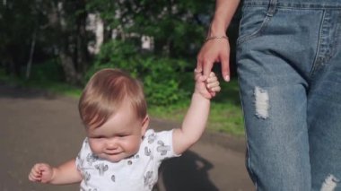 Güzellik annesi ve çocuğu parkta birlikte oynuyorlar. Güzel anne ve küçük oğlu dışarıda. Çocuk annesinin elini tutuyor. İlk adımları atan sevimli bir çocuğun portresi. Annelik kavramı