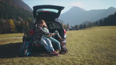 Güzel aşıklar harita üzerinde çalışıyorlar ve tatilleri boyunca arabada oturuyorlar. Uzun karantina sonrası yolculuklarında olan sevimli hippi genç bir çift. Sosyal uzaklık.