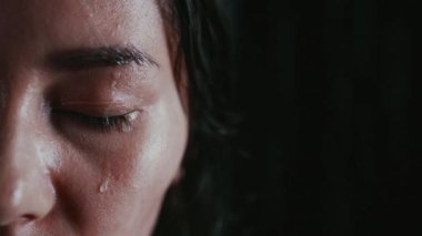 Karanlık arka planda yağmurda gözleri kapalı bir kadının yarı portresi. Yalnızlığı hissetti, yüzüne damlalar damladı. Zor seçimler kavramı, önemli kararlar. Gözlerde acı ve deneyim