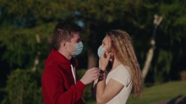 Genç adam ve kadın tıbbi maskeyi çıkarıp öpüşün. Salgın sona erdi. Sonunda karantina sona erdi. Güzel bir çift uzun bir yalnızlıktan sonra buluşur. Sağlık ve tıbbi konsept. Mutlu insanlar..