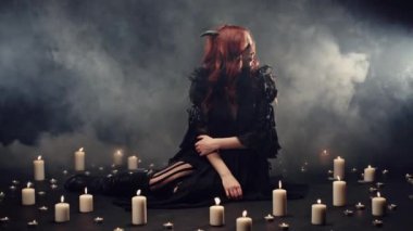 Boynuzlu cadı heceleme, ayin yapma ve doğaüstü güçleri çağırma. Mumlar dişi iblisin etrafına konuyor, dumanlar karanlıkta yükseliyor. Şeytan tarikatı, cadılar bayramı partisi ya da cadılar bayramı kostümü konsepti