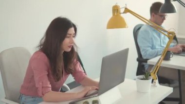 İnternette laptop kullanan bir iş kadını. Güzel, güler yüzlü, kendine güvenen genç bir kadın başarılı bir ticaret operasyonu yaptı. Kadın işçi ev ofisindeki ekrana bakıyor. Mutlu Milenyum Asyalı etnik köken kız öğrencileri.