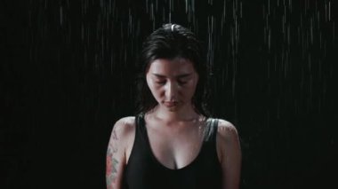 Su damlaları üzerine yağarken üzgün kız aşağı bakıyor. Siyah mayolu, yorgun yüzlü esmer yağmurda ıslanıyor. Görünüşe göre kadın pes etmiş. Mücadele, deneyim, acı kavramı.