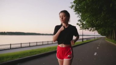 Nehrin setinde tek başına hareket ediyor. Güzel Asyalı kız parkta tek başına koşuyor. Dışarıda spor yapan genç bir kadın. Sağlıklı yaşam tarzı, fitness, aktivite, egzersiz, eğitim kavramı.