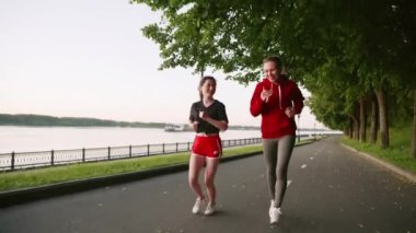 Parkta koşan kırmızı elbiseli iki genç kız. Arkadaşlarınla vakit geçir. Spor yaparken birbirleriyle iletişim kuran iki güzel kadın. Sabah ya da akşam nehir kenarında koşarken..