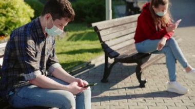 Kız ve erkek sosyal olarak birbirlerinden uzaklaşıyorlar. İnsanlar akıllı telefonları ya da cep telefonları aracılığıyla iletişim kuruyor ve dışarıdaki farklı banklarda tıbbi maskelerle oturuyorlar. Güvenli mesafeyi koru.