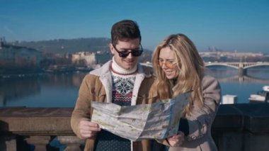 Prag haritasını inceleyen genç turistler. Turizm, seyahat, arkadaşlık, aşk, konsept. Çekimler kırmızı 4k, 10 bit renk