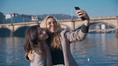 Prag şehrinde selfie çeken iki lezbiyen arkadaş. Gurur, Igbt, aşk kazanır, hoşgörü, gay konsepti. Çekimler kırmızı 4k, 10 bit renk