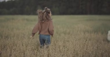 Köpeğiyle çimenlerde koşan komik bir kadın. Güzel bir kadının portresi ve doğada neşeli bir genç köpek. Kızla tüylü köpek arasındaki samimi arkadaşlık. Sınır çoban köpeği sevdalısı ve tarzı kavramı