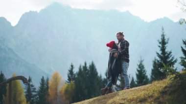 İskoçya 'da birlikte seyahat eden iki genç hippi. Dağda ya da tepede yürürken sarılıp öpüşen mutlu insan. İlişki kavramı, sosyal mesafe, sosyal uzaklık, yaşam tarzı..