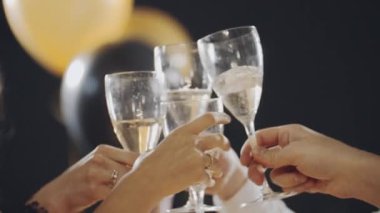 Kadınlar arkadaşlarını tebrik eder, gülümser, güler, ıslık çalar, bir kadeh şampanya içer ve şarap içerler. Çok ırklı genç kızların portreleri festival masasında oturup bayramı kutluyorlar..