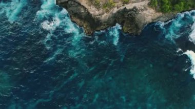 Doğal güçlerin gösterimi. Seyahat kavramı. Deniz gelgitlerinin kayalıklara çarpması için muhteşem bir manzara. İnanılmaz tropikal doğa, gök mavisi deniz dalgaları, bol köpük ve ağaçlı kayalar..