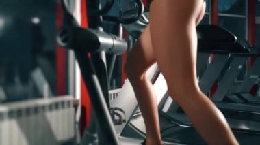 Güzel kas gevşemesi. Spor salonundaki koşu bandında çalışan güzel kız. Kadın bacak ve gövde kasları pompalıyor. Famale kendini çekici bir fiziksel forma sokuyor. Refah kavramı, aktivite.