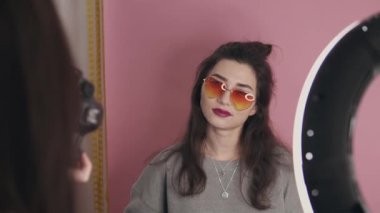 Asyalı kadın video blogcusunun profesyonel dijital video blogu. Pembe duvardaki şık kız içerik yaratıyor. Video blogu ve vloglama, nüfuz, sosyal medya konsepti ve yaşam tarzı oluşturma.