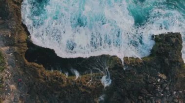 Tropikal kayalık adaların ve dalgaların havadan görünüşü. Şeytanlar lagünü yırtar. Gök mavisi dalgaların uçurumla buluşması, yükselen deniz köpüğünün inanılmaz arka planı. Doğal güç ve güzelliğin nefes kesici manzarası. Seyahat kavramı