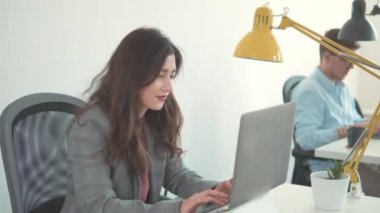 Mutlu Milenyum Asyalı etnik köken kız öğrencileri. İnternette laptop kullanan bir iş kadını. Güzel, güler yüzlü, kendine güvenen genç bir kadın başarılı bir ticaret operasyonu yaptı. Kadın işçi ev ofisindeki ekrana bakıyor..