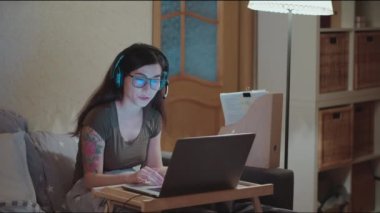 İnternette çalışıyorum. Evde kal. Kadın dizüstü bilgisayarla kendini izole etmeye çalışıyor. Ev ödevi, serbest ofis. Coronavirus karantinası. Destek servisinde çalışan kulaklıklı bir kız. Çağrı merkezi