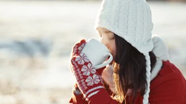 Kış sabahı parmaklarıyla aşk yapan bir kadın. Gün batımının parıltısı ellerinde. Güneş ışınları parlıyor. Tatil zamanı. Aşk sembolleri