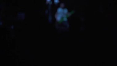 Rock konserinde dans eden bir kızın silueti. Eğlence ve geçmiş kavramı. Hayranları ve yıldızları olan bir gece kulübünde canlı performans. İnsanlar ellerini kaldırıp şarkı söylüyorlar..