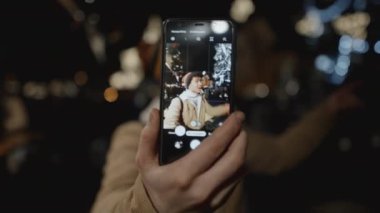 Erkek blogcu, Xmas saatinde kendini telefonla kaydediyor. Blogculuk, noel, yeni yıl, yaşam tarzı, tatil konsepti. RED kamera, 10 bit klonlama