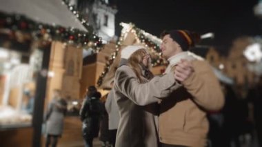 Prag 'da gece meydanında dans eden mutlu çift. Aşk, aile, Noel, yeni yıl, tatil konsepti. RED kamera, 10 bit klonlama