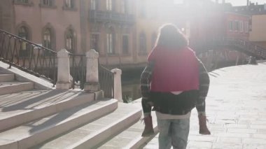 Yakışıklı Avrupalı adam Venedik sokaklarında muhteşem Asyalı kadınını sırtında taşıyor. Genç aşık hippi çift uzun bir geçmişi olan güzel bir ülkede eğleniyor. Aşk kavramı.