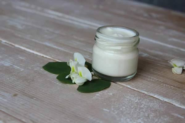 Crema ecológica con flores blancas en el fondo de las tablas —  Fotos de Stock