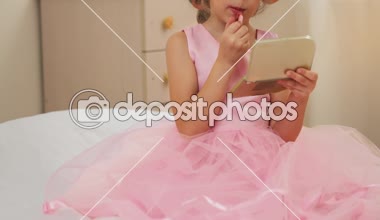 Güzel kız evde parti için hazırlanıyor. Şirin çocuk dudak renklendirme.