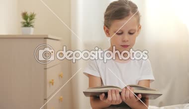 Güzel kız evde hikaye okuma. Sabahleyin yatakta oturmuş kitap ile şirin çocuk.