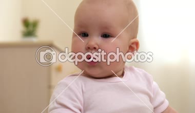 Bir şey de merakla bakarak kız tatlı bebek. Yatak odasında oturmuş, evde rahatlatıcı sevimli çocuk.