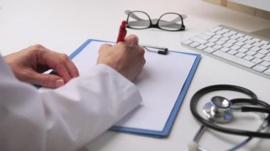 Tıbbi rapor yazma kadın doktor ofisinde masa başında çalışma.